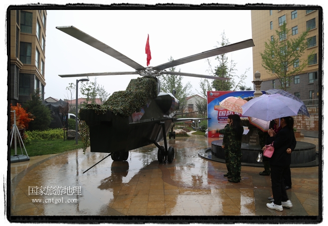 小區(qū)突然出現(xiàn)“飛機(jī)坦克”，其中殲15艦載戰(zhàn)斗機(jī)一架、99式主戰(zhàn)坦克一輛、武直-10武裝直升機(jī)一架，吸引了眾多市民雨中圍觀、合影。